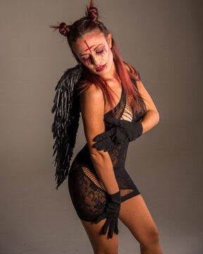 Fallen angel woman posing with devil makeup