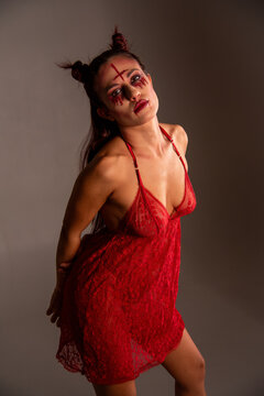 Woman wearing devilish makeup and red lace lingerie