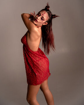 Woman portraying demon character in red lace lingerie