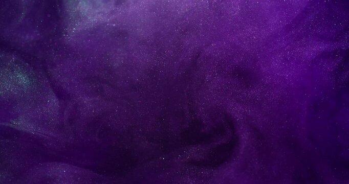 Ink splash. Mist art. Defocused purple lilac color sparkling liquid neon glitter texture spreading on abstract dark black art background.