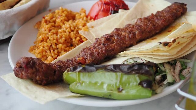 Traditional Turkish Adana Kebab Served with Bulgur and Grilled Vegetables