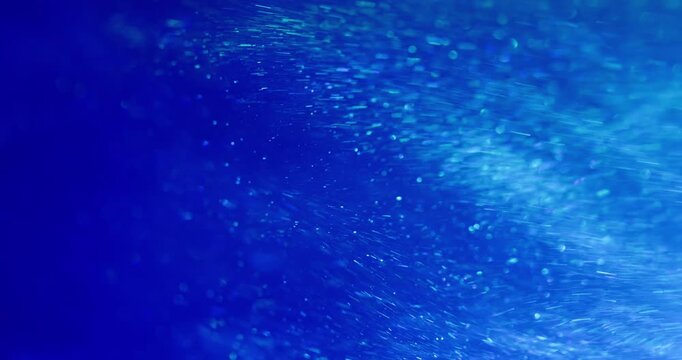 Blur shimmer dust. Shiny texture. Blue neon color radiant illuminated optical flash floating on abstract art bokeh light background.