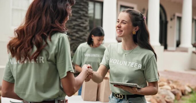 Happy, woman and volunteer outdoor with handshake, welcome and partnership for community service. Smile, team and shaking hands at event with tablet, introduction and agreement for charity enrollment
