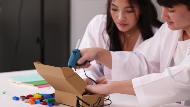 Teenage Students Using Hot Glue Gun for Science Project