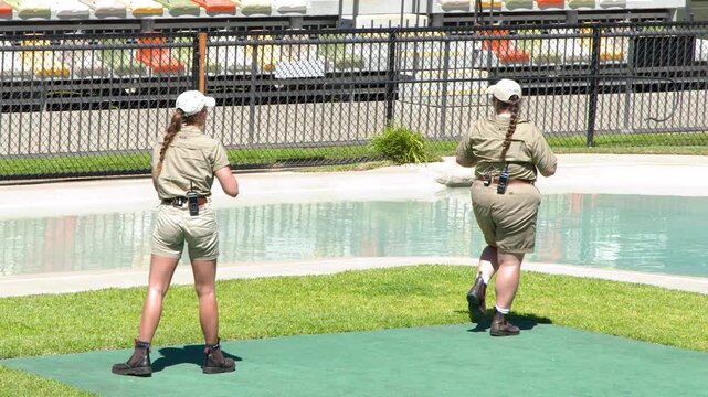 Two Female Zookeepers in Khaki Uniforms Walking in Zoo Arena