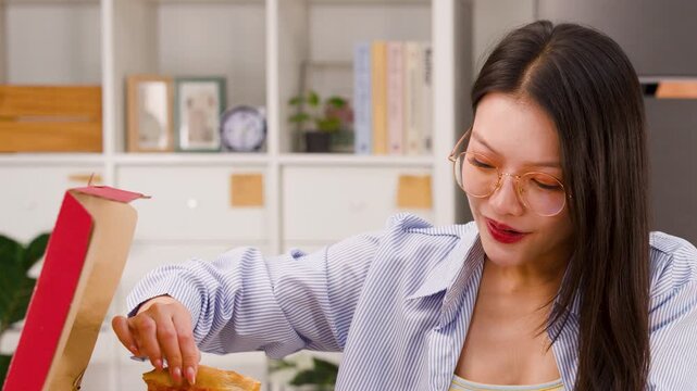 Young Asian Woman Opening Pizza Box and Holding a Slice Excitingly