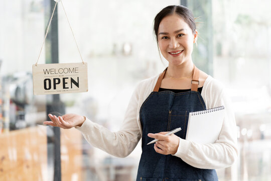 Smiling Asian Female Small Business Owner Standing in Cafe with Open Sign