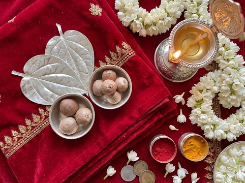 Traditional Indian wedding ritual items with velvet fabric flowers and oil lamp