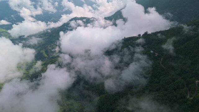 Drone view over the vast Kathmandu Valley urban sprawl and green farmland under heavy grey clouds and a hazy horizon in Nepal