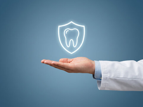 dentist hand presenting a protective tooth shield icon for dental insurance oral health prevention and professional dental care