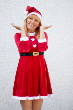 Full Length Portrait of Cheerful Woman in Red Santa Costume on White Background