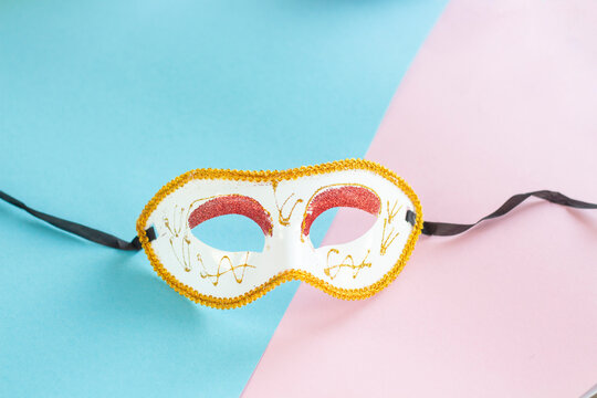White and Gold Carnival Masquerade Mask on Pink and Turquoise Pastel Background