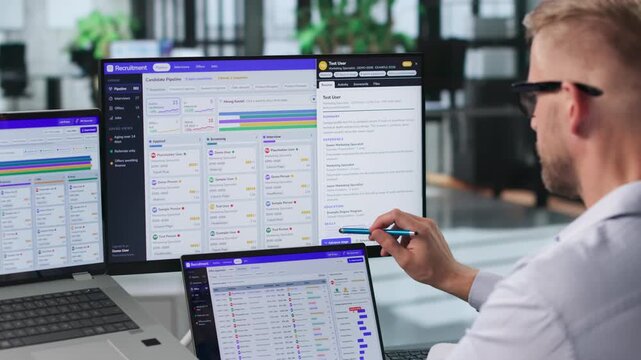 Recruiter Reviews Candidate Resumes On Laptop