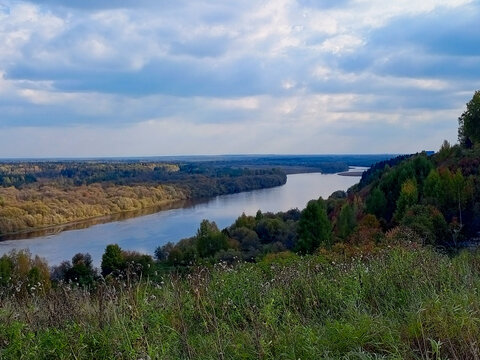 Beautiful landscape with river and blue sky with clouds in autumn.