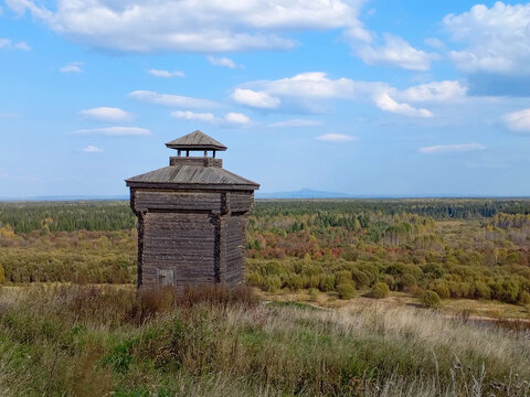 Old wooden watchtower in the forest on a background of blue sky in Cherdyn, Russia