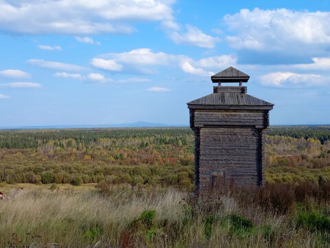 Wooden watchtower on the background of the autumn forest and blue sky in Cherdyn, Russia