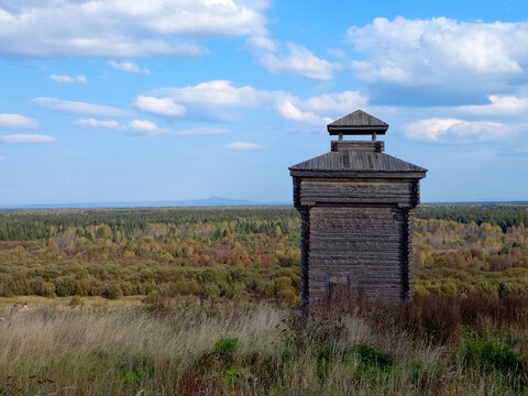 Old wooden watchtower in the forest on a background of blue sky in Cherdyn, Russia