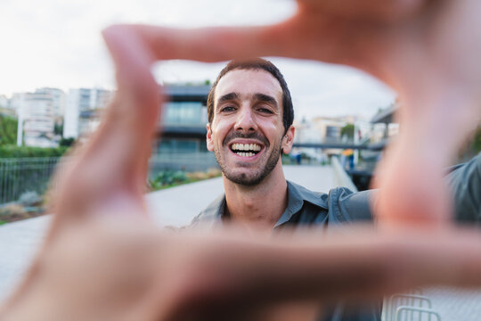 Man smiling framing vision with his hands