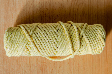 Coiled yellow rope on a wooden surface © Володимир Виповський