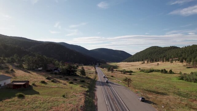 Aerial video following 2 car on highway 36 leaving Estes Park, Co