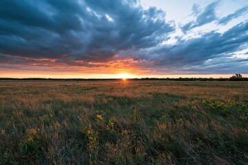 Naklejka premium The Sunset Over Open Prairie Field At Dusk With Dramatic Clouds