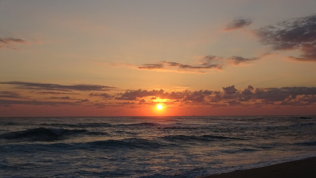 Peaceful Sunrise Over the Calm Sea and Gentle Waves.
A serene landscape of the sun rising over the tranquil ocean, featuring soft gentle waves rolling onto the shore under a peaceful morning sky.