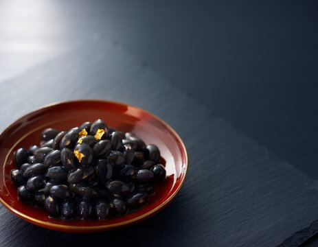 Glossy simmered black soybeans kuromame with gold leaf for osechi