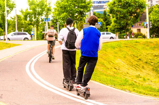 A guy rides an electric scooter in the summer Park
