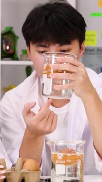 Teenage Student Examining Liquid in Beaker During Science Experiment