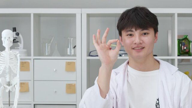 Teenage Student Scientist in Lab Coat Giving OK Hand Gesture