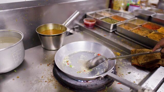 Chef Saut&Atilde;&copy;ing Garlic and Spices in Frying Pan in Commercial Kitchen