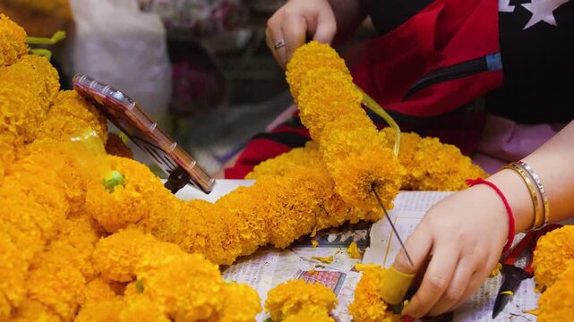 Woman Handcrafting Yellow Marigold Garland for Religious Offering