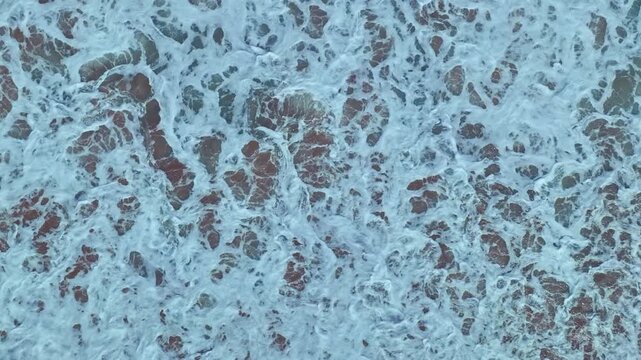 aerial top view the serene beauty of the scenery is breathtaking. 
The surface of the waves crashing on the sand breaks into beautiful patterns.
4K UHD 50 frame per second. Video slow motion Clip