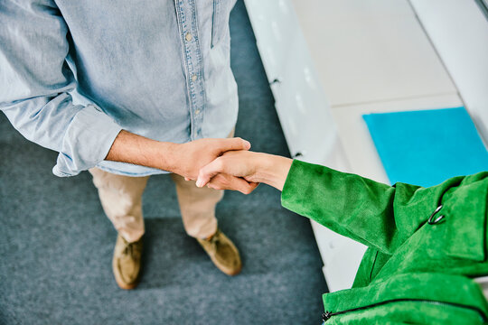 Man and woman shake hands in the office to seal a business deal