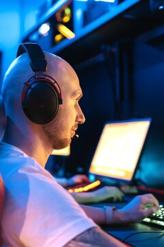 A focused gamer plays a video game on his computer