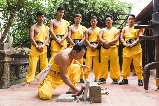 Vietnam, Hanoi, men exercising kung fu, man slabs flagstone