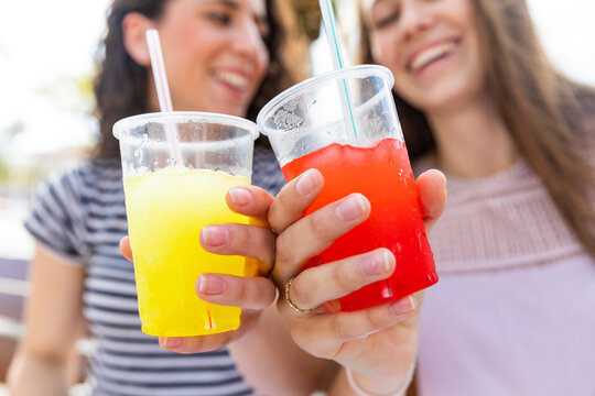 Close-up of two female friends enjoying a fresh slush