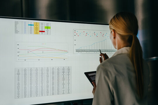 Businesswoman analyzes data on a large screen in the office