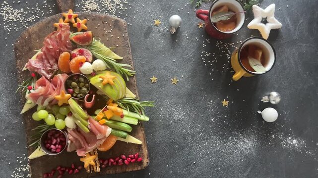 Christmas tree shaped  charcuterie board on dark background, top view