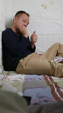 Vertical: Man struggling with nicotine craving is engaged in an internal battle. The man is trying to quit smoking. The man is trying to use willpower to quit smoking. Man try to smoke cigarette.
