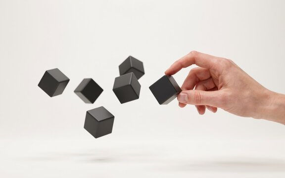 Hand selecting black wooden cubes in mid-air. Growth strategy visualization with floating blocks