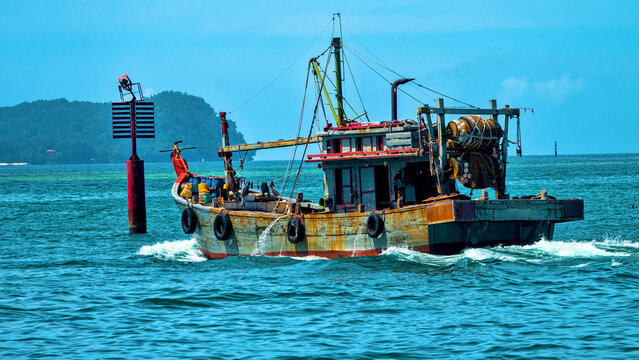 An old wooden fishing schooner goes out to catch fish and shrimp. Malaysia, South China Sea.