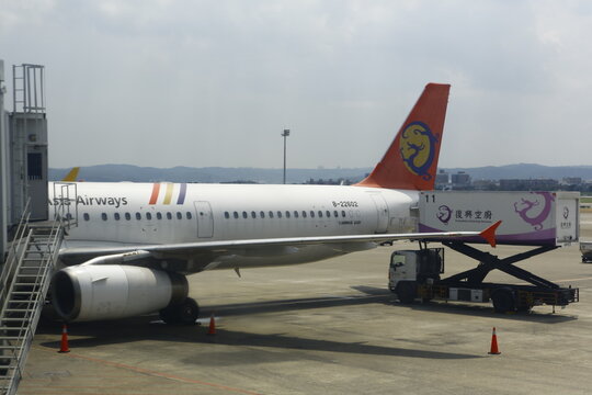 Commercial passenger airplane undergoing catering ground service at airport.