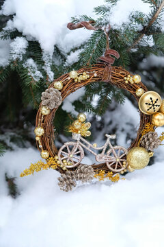 festive decorations for Christmas, New year holidays. beautiful decorative wreath with bicycle figurine on snowy christmas tree outdoor. 