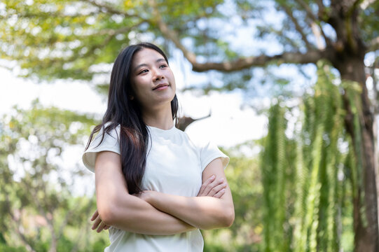 Asian Woman Standing with Crossed Arms Looking Confident in Park