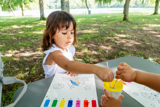 White child painting bird coloring page outdoors