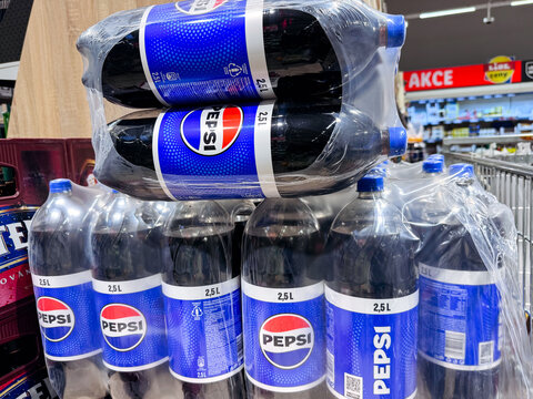 Prague, Czech Republic - September 17, 2026: Pepsi bottles wrapped in clear plastic packaging on a supermarket shelf with branded blue labels and stacked soft drink multipacks