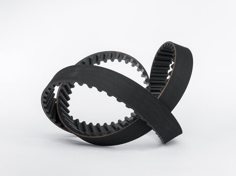 New rubber toothed timing belt for car engine maintenance isolated on white