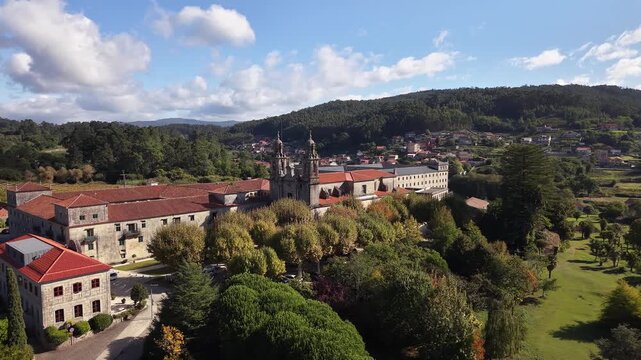 Historic poio monastery building standing among vineyards and green hills of galicia