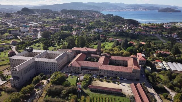 Historic poio monastery building standing among vineyards and green hills of galicia